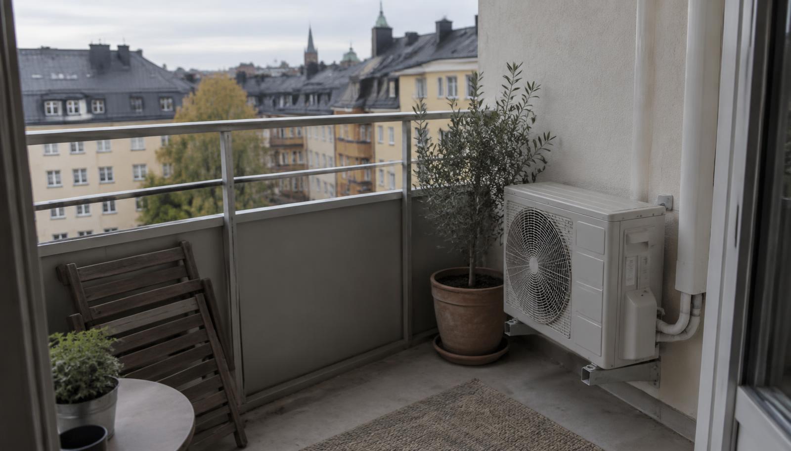 Balkong i svenskt flerbostadshus med en liten utedel monterad på väggen bredvid en krukväxt